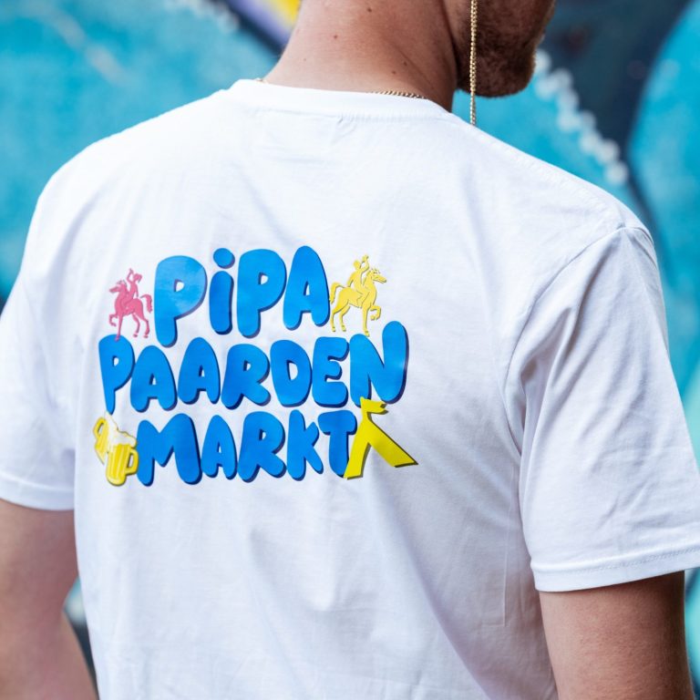 Witte T-shirt met de tekst "PIPA PAARDENMARKT" in kleurrijke letters.